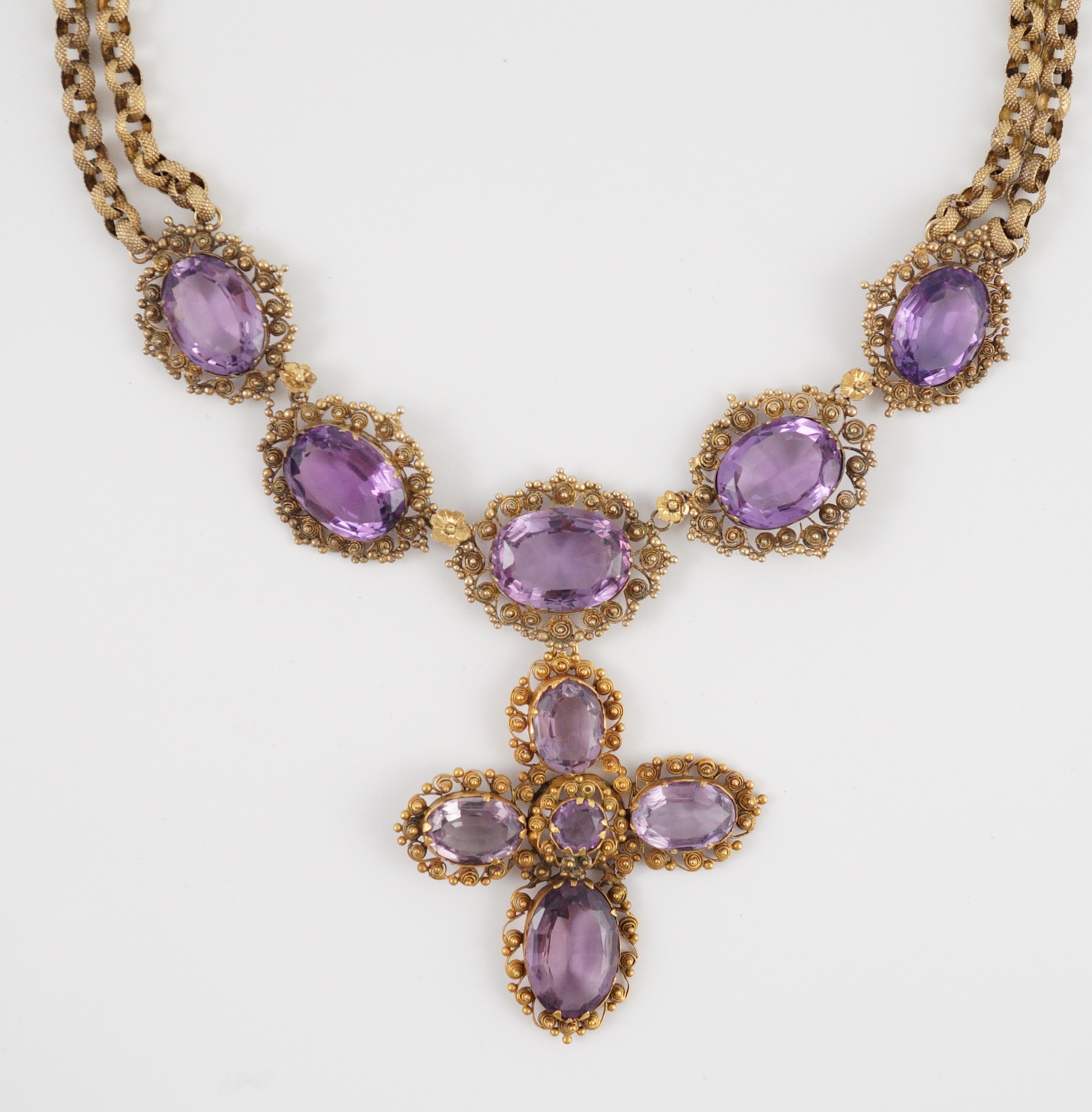 An early 19th century gold and eleven stone oval cut amethyst set pendant necklace and a similar cross pendant (repair)